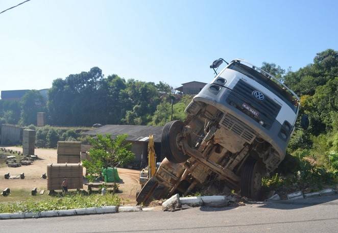 Após descer morro de ré, caminhão fica suspenso em barranco — foto 1