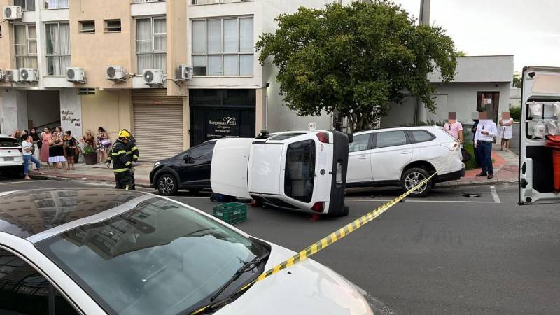 Carro dos Correios bate em veículo estacionado e tomba no Centro de Criciúma — foto 1