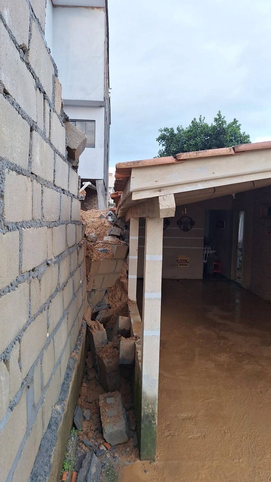Família é levada para casa de parentes após muro cair sobre residência — foto 1