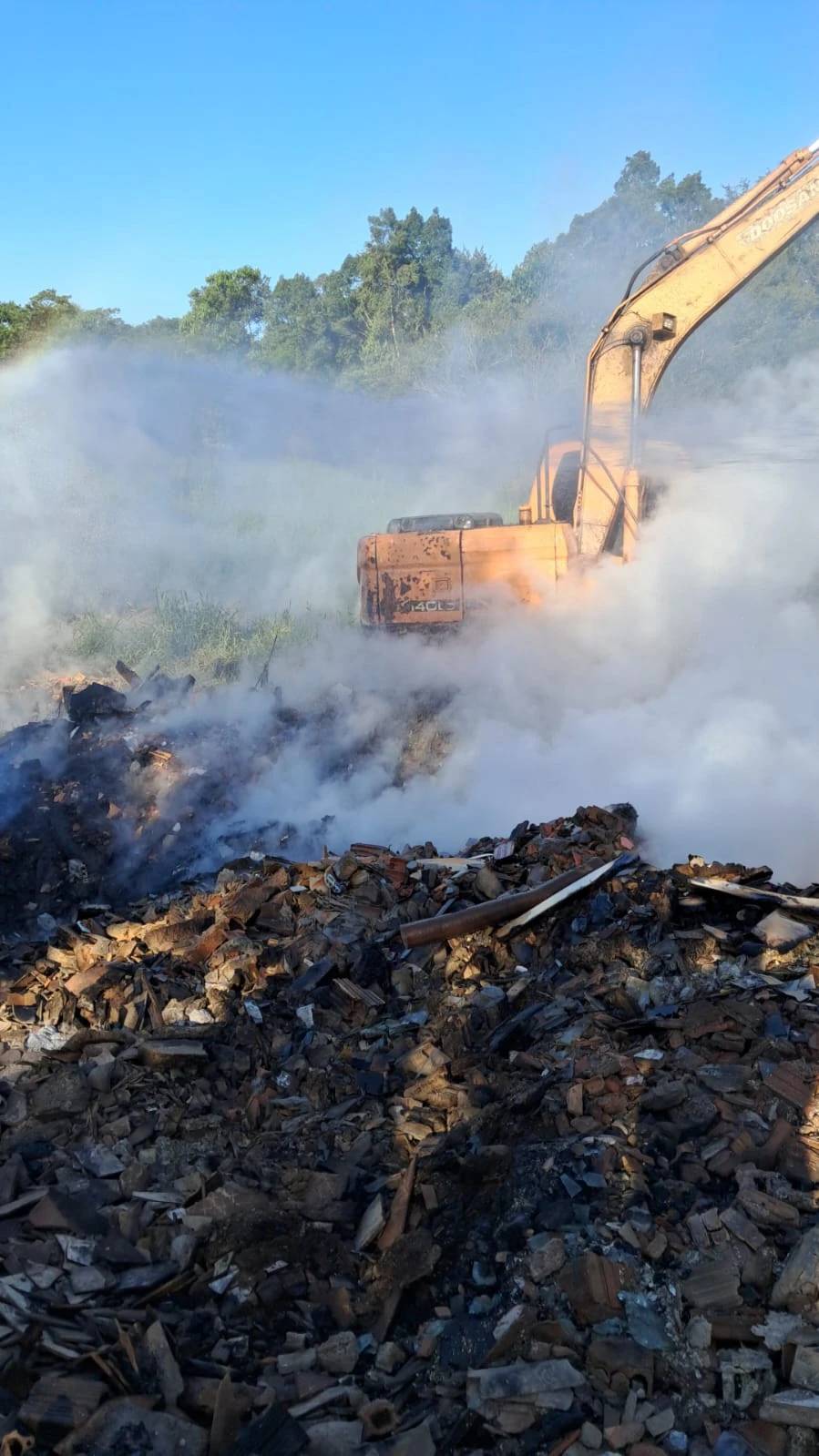 Bombeiros monitoram queima de material profundo em terreno com entulhos — foto 2