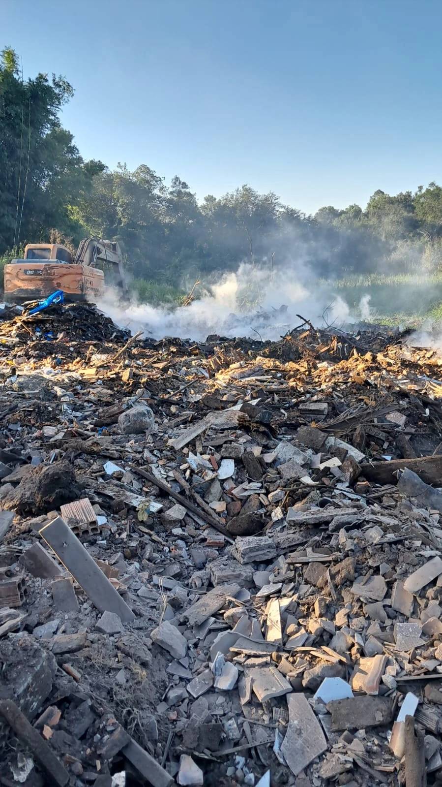 Bombeiros monitoram queima de material profundo em terreno com entulhos — foto 1