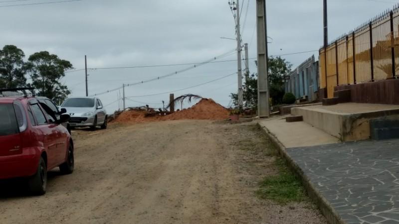 Após 30 anos de poeira, moradores interditam rua
