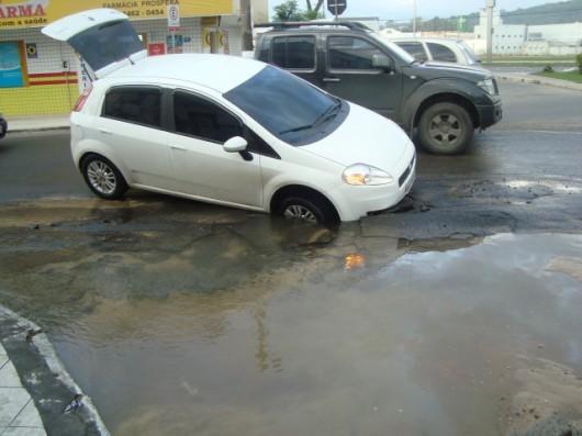 Rompimento de canos deixa asfalto frágil e carro cai em buraco
