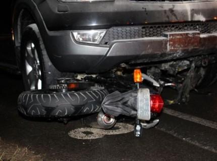 Após queda de piloto, motocicleta para embaixo de caminhonete