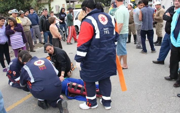 Motociclista fica ferida ao colidir em dois caminhões 