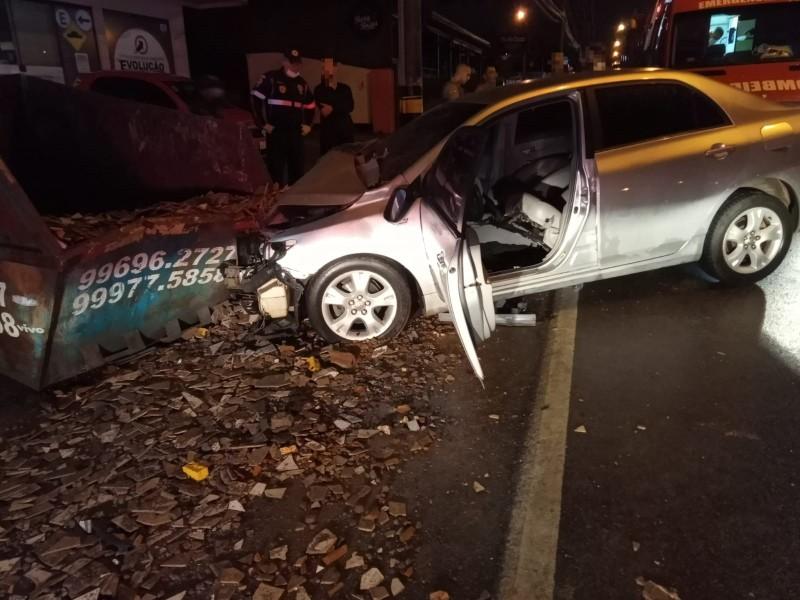 Carro colide em caçamba de entulhos e duas pessoas ficam feridas