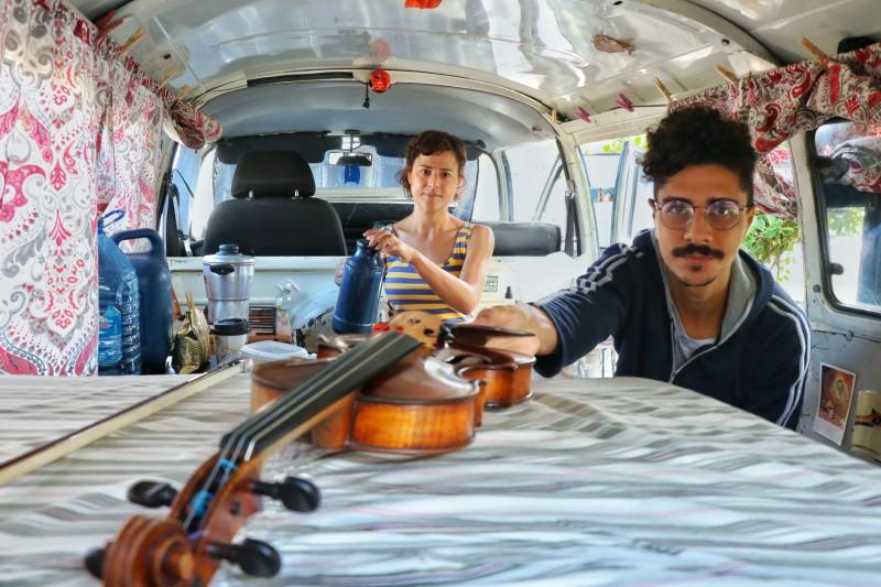 A bordo de uma Kombi, casal vive de música