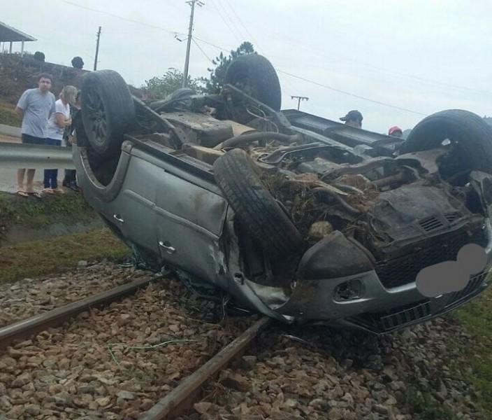 Após colisão, veículo sai da pista, capota e para sobre a linha férrea