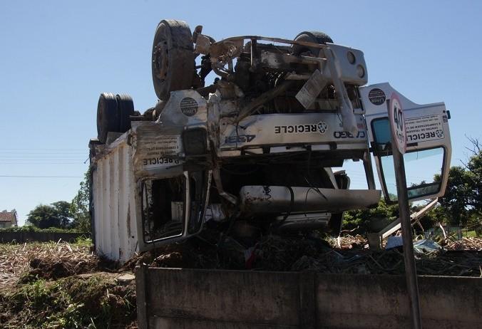 Sem freio, caminhão capota em morro e motorista fica inconsciente 