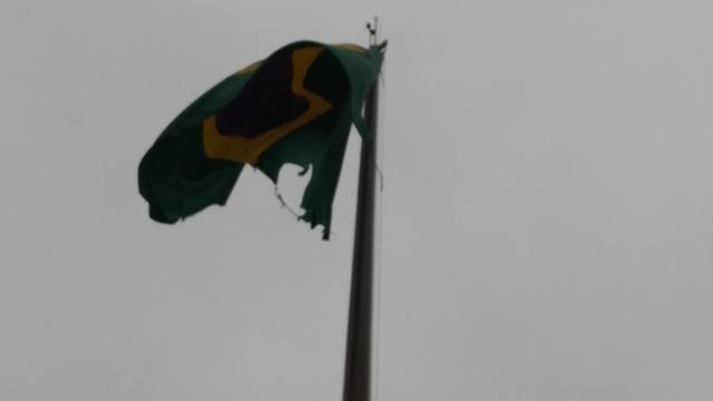 Tremula no horizonte a surrada bandeira nacional