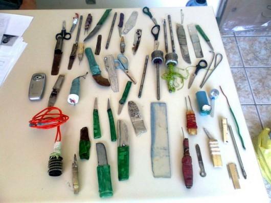 Celular e espetos artesanais achados em pente-fino