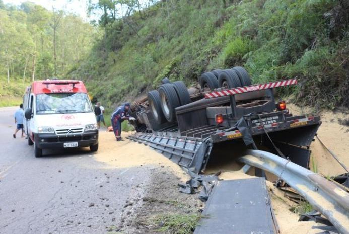 Caminhão tomba e motorista fica preso às ferragens 