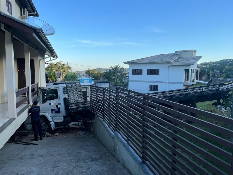 Caminhão carregado com madeira invade casa no bairro Colonial em Criciúma
