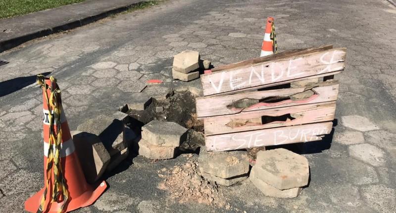 Moradores colocam placa em buraco no meio da rua em Criciúma 