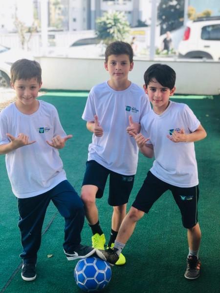 Meninos constroem suas trajetórias com cadernos nas mãos e bola nos pés