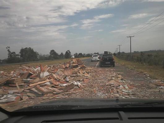 Caminhão tomba na BR-101 e carga de pisos cai sobre a rodovia