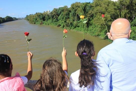 Rosas jogadas em rio lembram enchente que destruiu Tubarão 