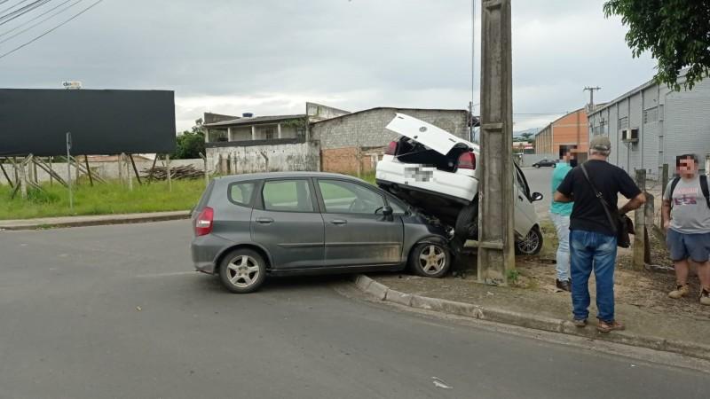 Carros colidem em cruzamento e um fica sobre o outro