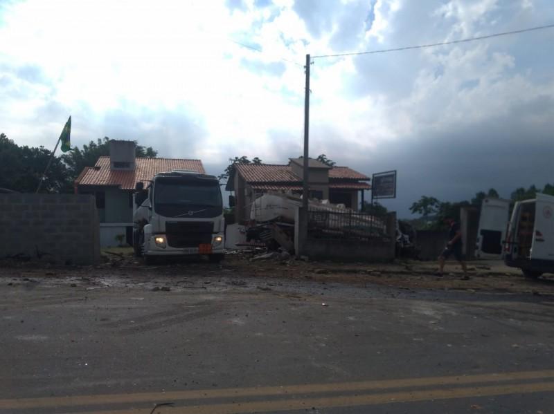 Caminhão capotou antes de invadir casas; carga está sendo transbordada