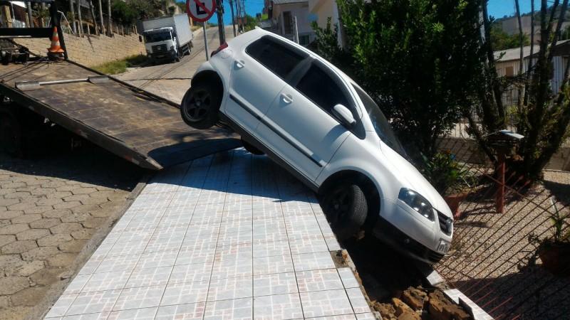 Carro desgovernado desce ladeira e atinge portão de residência 