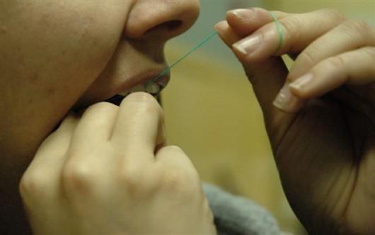 Uso correto do fio dental previne doenças bucais